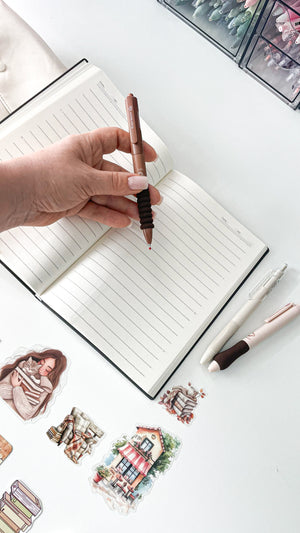 Cozy journaling setup with an A5 notebook, coffee-themed pens and bookish stickers from the Morning Coffee Stationery Gift Bundle.