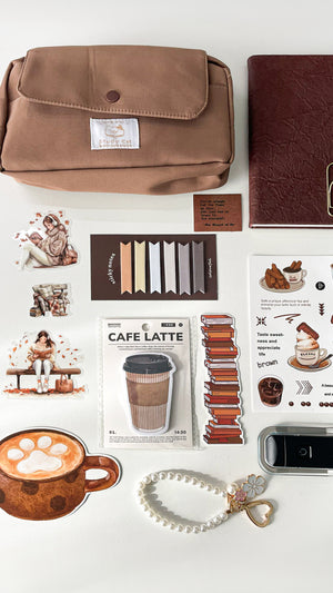 Close-up of a premium coffee-themed stationery gift bundle featuring a pencil pouch, A6 notebook, coffee memo pad, stickers, bookmarks, pearl keychain charm, and LED reading light.