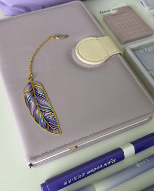 Luxury purple journal with a feather bookmark and writing essentials from the Essential Purple Stationery Gift Bundle