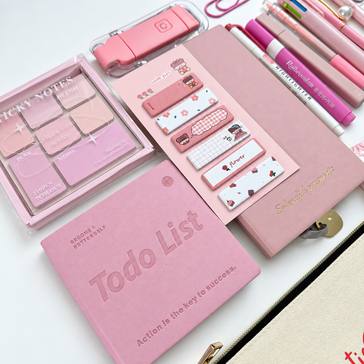 Close-up of pink to-do notebook, A6 lined journal, decorative sticky notes and Bestie canvas pouch in a curated stationery gift set.
