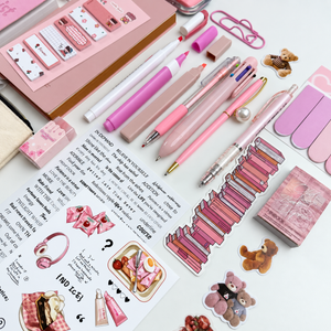 Close-up of pink gel pens, pearl ballpoint pen, multicolor pen, mechanical pencil, highlighters and acrylic marker for journaling.