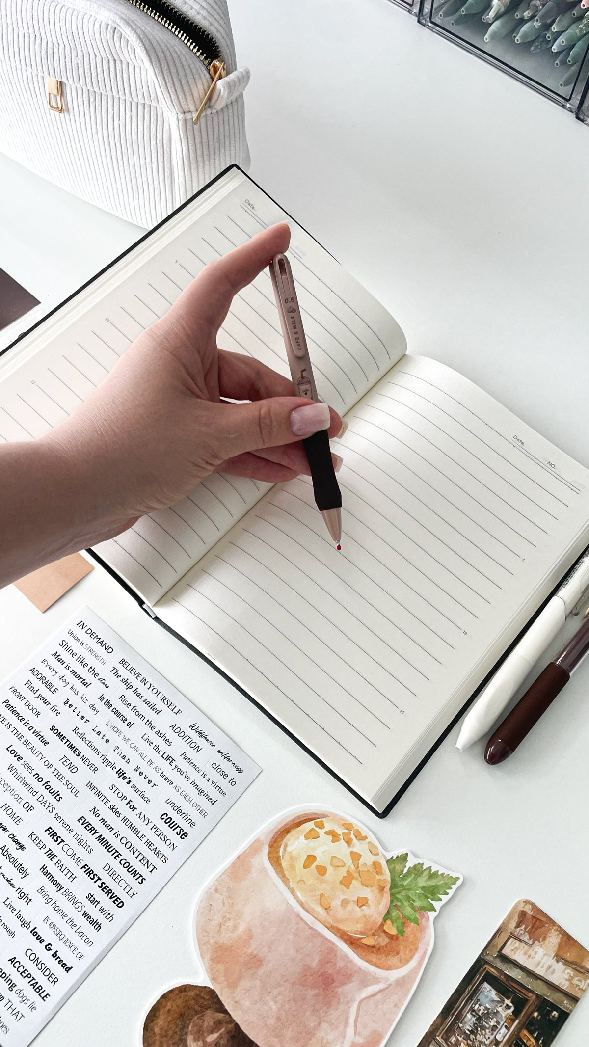 Writing with a coffee-themed gel pen in a cream notebook from the Morning Coffee Stationery Gift Bundle, featuring cozy aesthetic stationery for book lovers and journal enthusiasts.