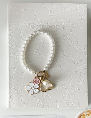 Cream aesthetic notebook paired with a pearl keychain charm from the Morning Coffee Stationery Gift Bundle for book lovers, journaling, and cozy stationery collections.