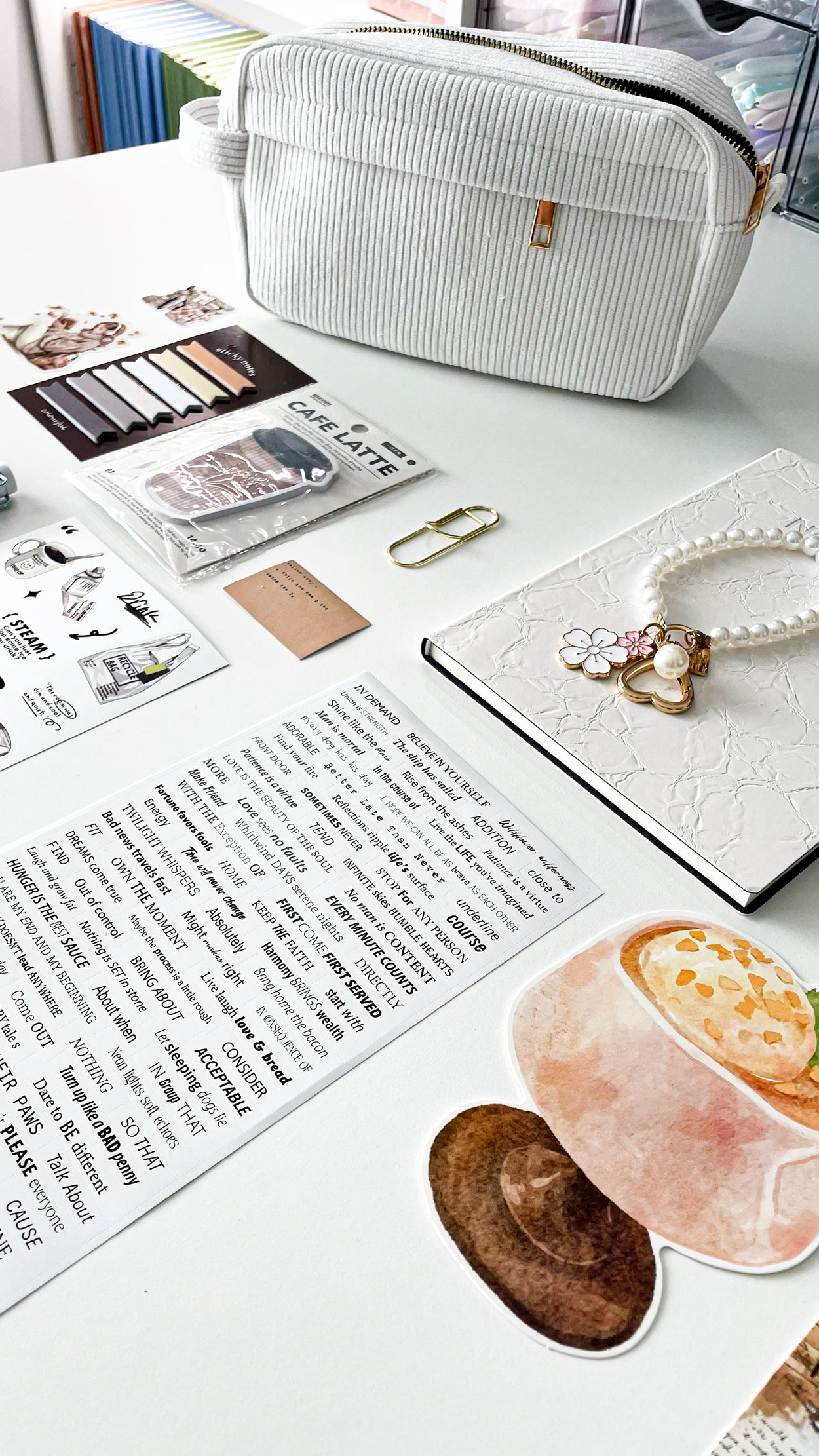 Lifestyle photo of the Morning Coffee Stationery Gift Bundle featuring a cream corduroy pencil pouch, cream notebook, pearl keychain, coffee-themed stationery, bookmarks, sticky notes, and journaling accessories.