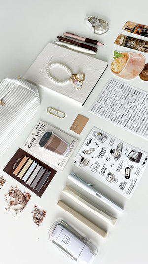 Flat lay of the Morning Coffee Stationery Gift Bundle with a cream notebook, corduroy pencil pouch, coffee-themed stationery, bookmarks, sticky notes, and cozy journaling essentials.