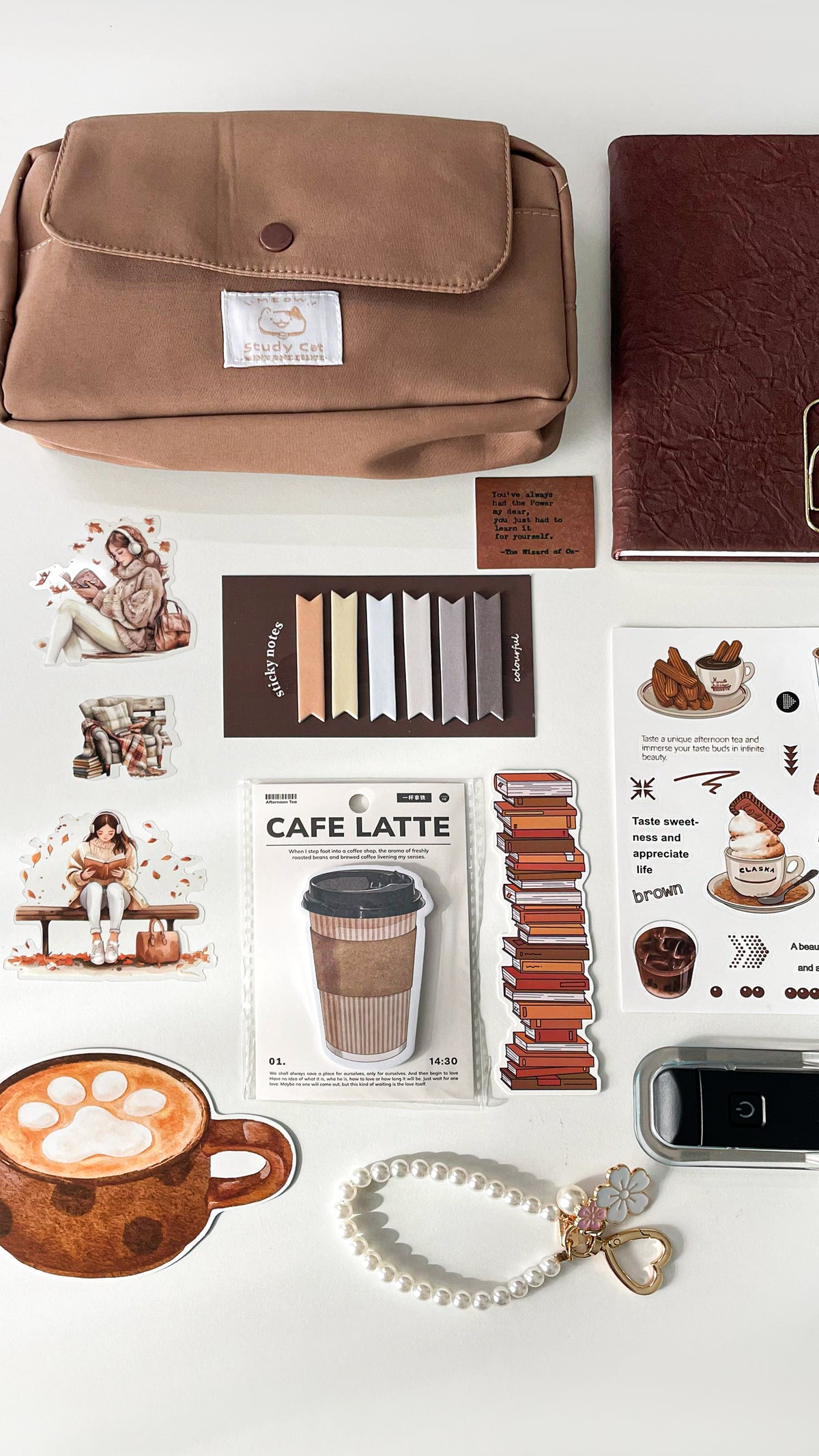     Close-up of a premium coffee-themed stationery gift bundle featuring a pencil pouch, A6 notebook, coffee memo pad, stickers, bookmarks, pearl keychain charm, and LED reading light.