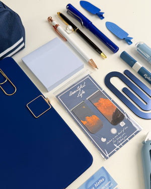 Blue book lover gift with notebook, pens, sticky notes, bookmarks and aesthetic stationery accessories for reading and journaling.