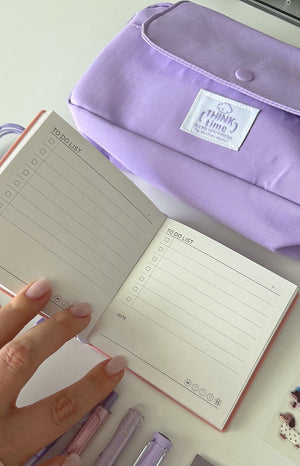 Open notebook from the Essential Purple Stationery Bundle with to-do list pages and a lavender pencil pouch