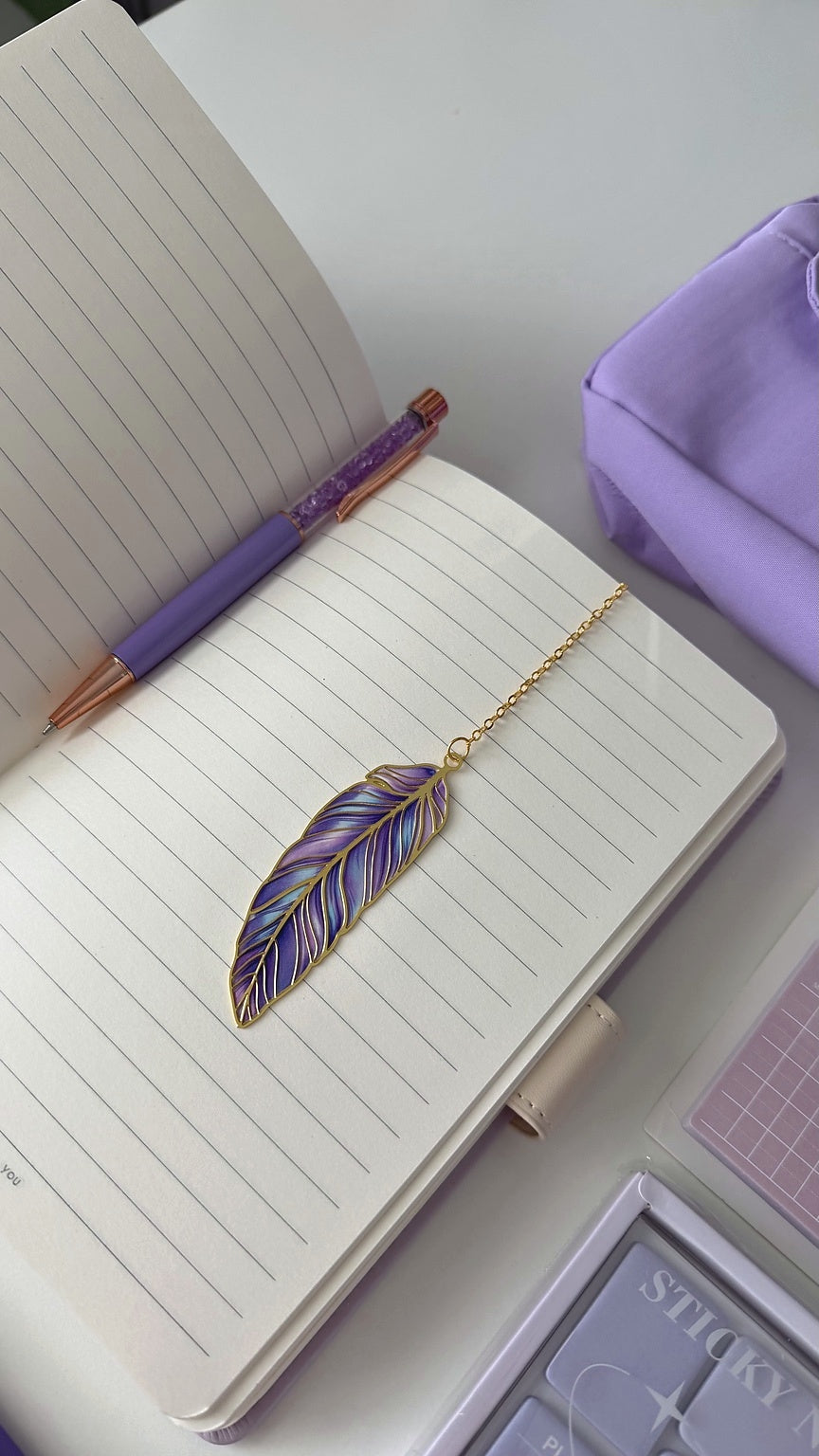 Open notebook with a purple pen and feather bookmark from the Essential Purple Stationery Gift Box