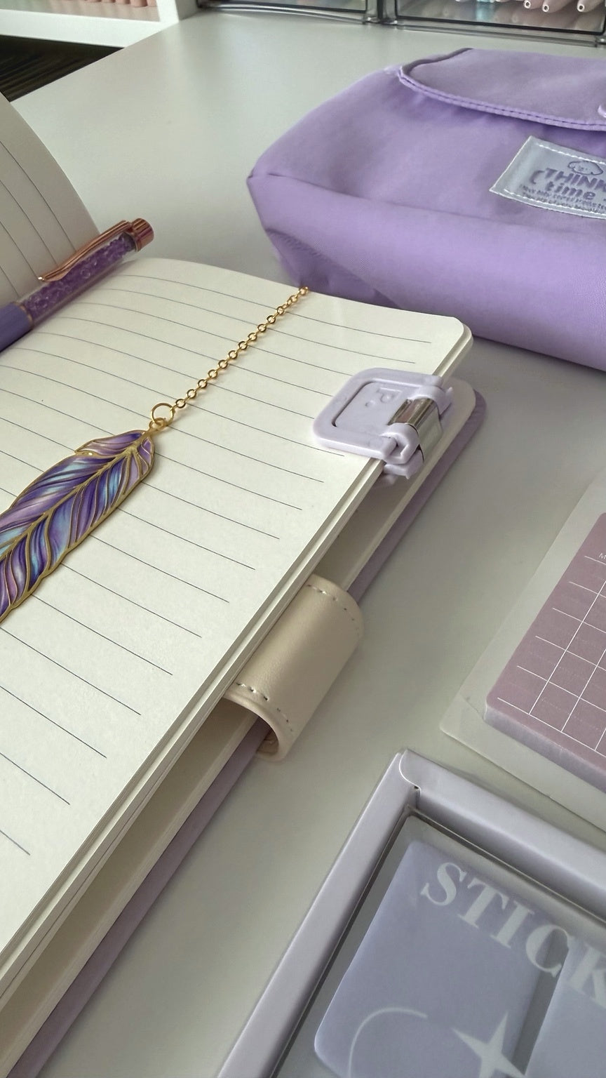 Open notebook with a feather bookmark and planner from the Essential Purple Stationery Gift Box