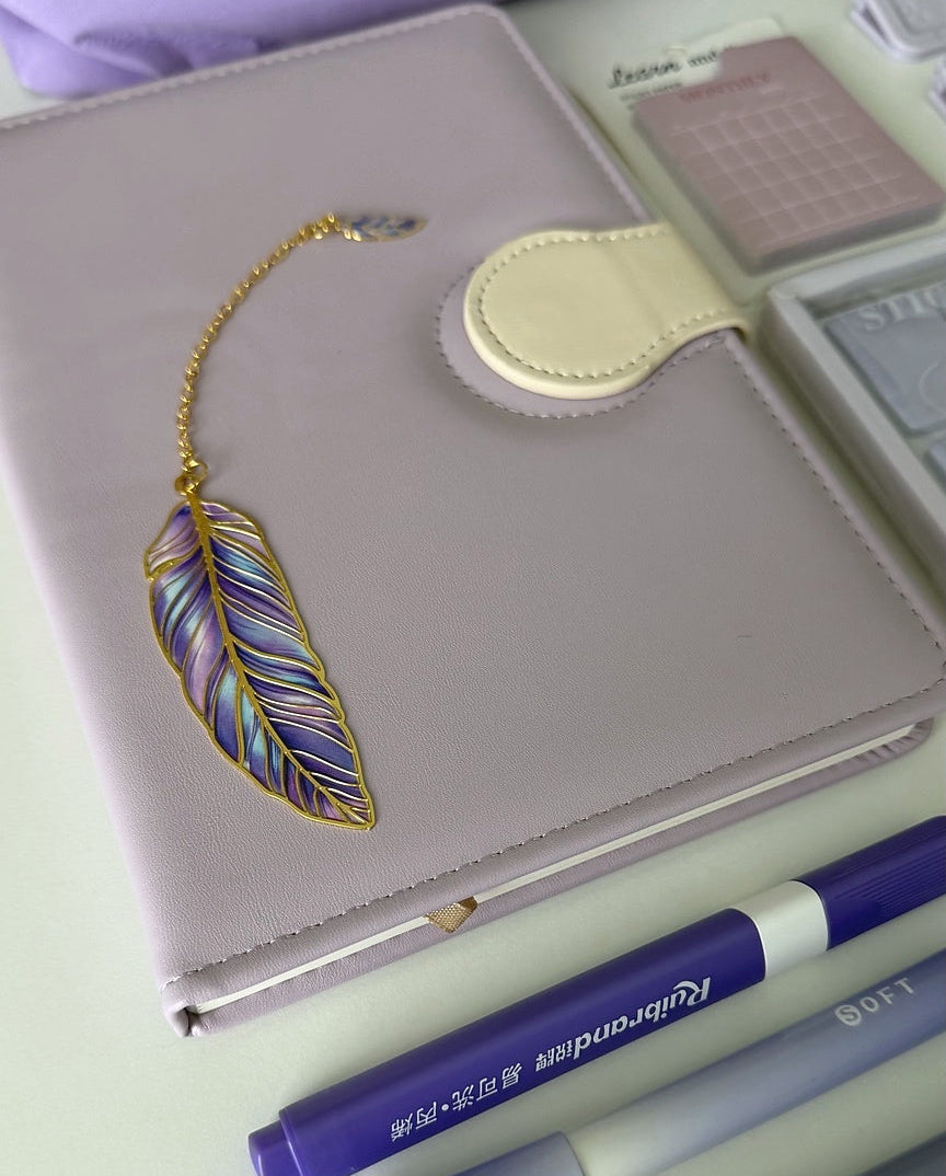 Luxury purple journal with a feather bookmark and writing essentials from the Essential Purple Stationery Gift Bundle