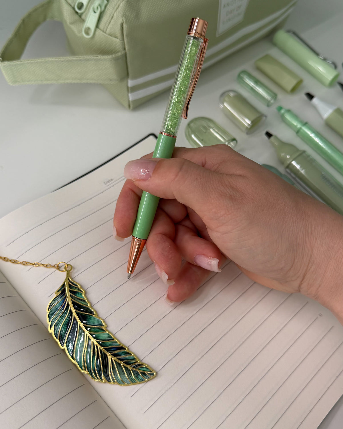Sage green glitter pen and feather bookmark from the Sage Garden bookish stationery gift box for journal lovers. 🌿📖