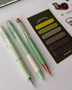 Sage green pens and sticky notes from a stationery gift box, a thoughtful gift for stationery and journal lovers.